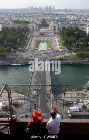 I turisti sottolineare i punti di riferimento dal secondo piano della Torre Eiffel a Parigi. Foto Stock