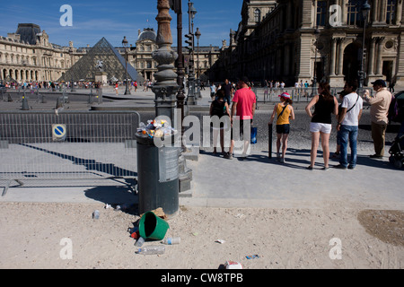 Traboccante cestini e turisti all'ingresso delle Tuillerie Gardens al di fuori del Louvre museo d'arte. Foto Stock