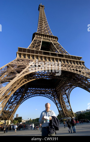 Parigi, sotto la Torre Eiffel un turista guarda a una mappa Foto Stock