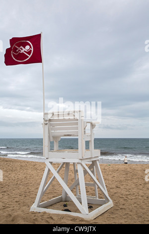 Una bandiera rossa su un bagnino's chair in Cape Cod National Seashore vieta il nuoto a causa di batteri nell'acqua. Foto Stock