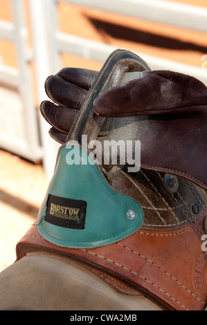 Dettaglio del a doppio spiovente bronc riding al Mount Isa Rodeo 2012 con close-up di sella e guanto in pelle Foto Stock