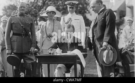 Presidente Calvin Coolidge (1872-33) firma stanziamento fatture per i veterani del Bureau sulla south lawn durante il giardino Foto Stock