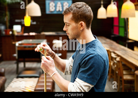 L'uomo giocando a biliardo nel bar Foto Stock