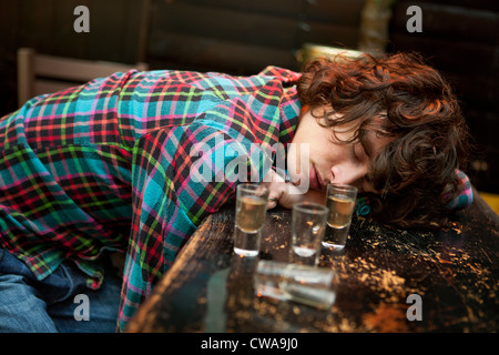 Uomo ubriaco crollati sulla barra addormentato Foto Stock