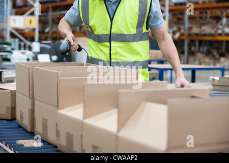 L'uomo utilizzando il lettore di codici a barre nel magazzino Foto Stock