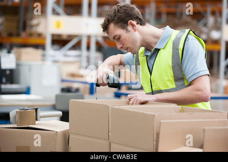 L'uomo utilizzando il lettore di codici a barre nel magazzino Foto Stock