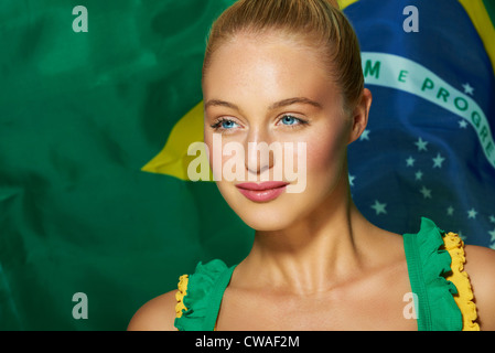 Giovane donna di fronte a bandiera brasiliana Foto Stock