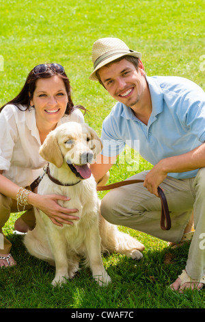 Giovane coppia felice con il Labrador cane sorridente in posizione di parcheggio Foto Stock