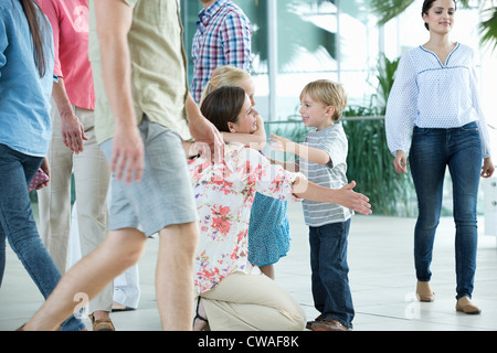 La madre abbraccia i bambini in aeroporto Foto Stock