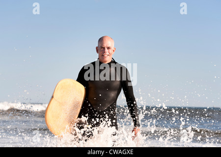 Surfer in mare con la tavola da surf Foto Stock