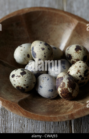 Uova di quaglia in ciotola di legno Foto Stock