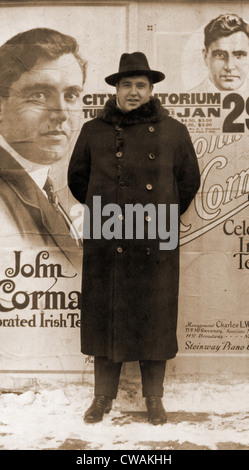 John McCormack (1884-1945), irlandese-americano nato il tenore di intera lunghezza verticale, in piedi di fronte a poster annunciando un imminente Foto Stock