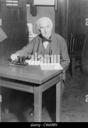 Thomas Edison, seduto alla scrivania, dimostrando un vecchio trasmettitore telegrafico nel suo di West Orange, nel New Jersey, laboratorio, 1930.