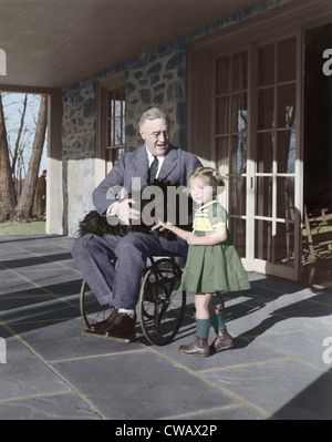 Il presidente Franklin Delano Roosevelt nella sua sedia a rotelle sul portico in cima Cottage in Hyde Park, NY, con Ruthie Bie e Fala. Foto Stock