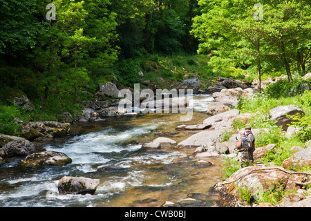 Due anziani pescatori pesca sportiva sulle rive del fiume Lyn (Est) vicino a Lynmouth, North Devon, Inghilterra, Regno Unito Foto Stock