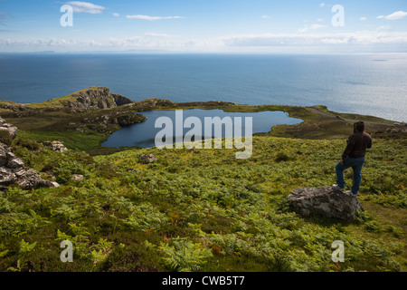 Una panoramica del lago alla Slieve League scogliere con l'Atlantico al di là, sulla costa occidentale di Donegal, Repubblica di Irlanda. Foto Stock