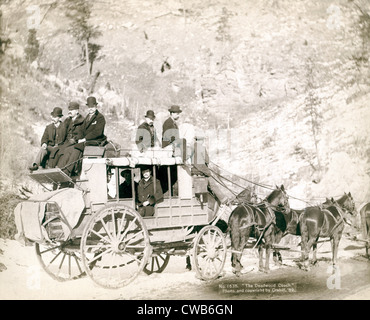 Il Pullman Deadwood. Vista laterale di un stagecoach; formalmente vestiti uomini in seduta e sulla parte superiore del pullman. Deadwood, SD. John C. Foto Stock