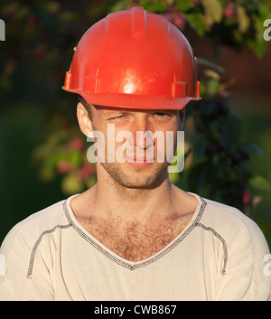 Closeup Ritratto di giovane lavoratore edile con gli occhi di strizzare gli occhi Foto Stock