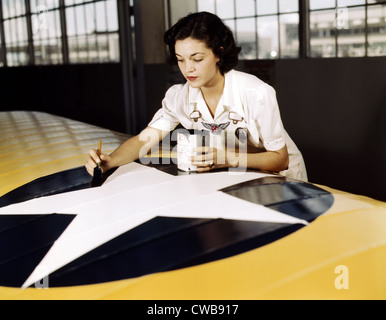 Servizio civile lavoratore dipinge le insegne americano su un US Navy ala di aeroplano, Naval Air Base, Corpus Christi, Texas 1942 Foto Stock