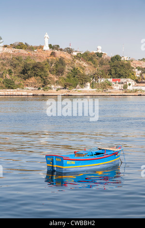 Barca a remi in Havana Harbour con la statua di Gesù Cristo in background Foto Stock