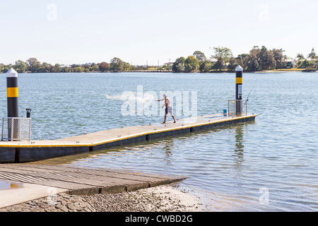 L'uomo la colata di una pesca di esche net su un pontile galleggiante a Maroochy River, Maroochydore on Queensland Sunshine Coast, Australia Foto Stock