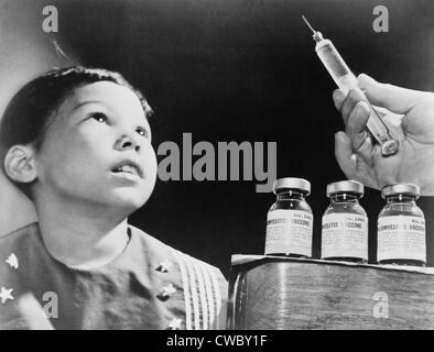 Bambino guarda una siringa con la poliomielite vaccino. Il vaccino di Salk, sviluppato nel 1955, è stato distribuito in tutto il mondo e Foto Stock