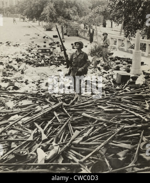 American p.f. in piedi su un gran mucchio di armi italiane in una strada a Palermo, Italia, il 6 agosto 1943. Palermo, Foto Stock