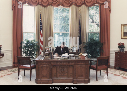 Il presidente Reagan lavorando alla sua scrivania in ufficio ovale. 15 luglio 1988. PO-USP-Reagan NA-12-0101m Foto Stock