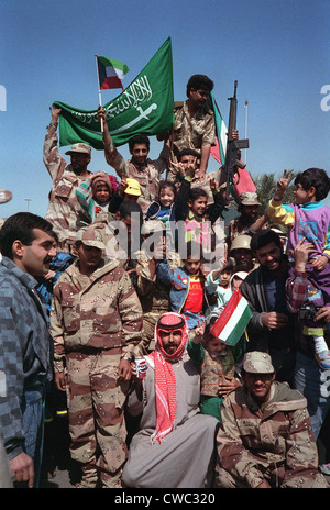 I civili e le forze della coalizione di forze militari in Kuwait onda e Saudi Arabian bandiere per celebrare il ritiro delle forze irachene dal Foto Stock