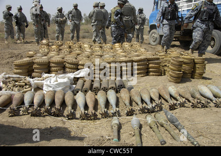 Nazionale iracheno e di polizia di soldati USA scopri le armi di cache di 29 120-mm colpi di mortaio 466 2.2 75 miniere miniere 2.4 sette Foto Stock