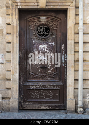 Una porta nella parte interna della città di Parigi danneggiato da atti di vandalismo graffiti Foto Stock
