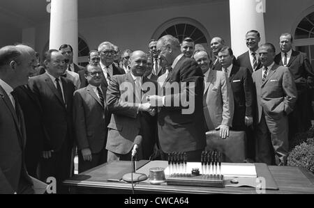 LBJ E la grande società programmi. Il presidente Lyndon Johnson scuote HUD Segretario, Robert Weaver, dopo la firma dell'alloggiamento e Foto Stock