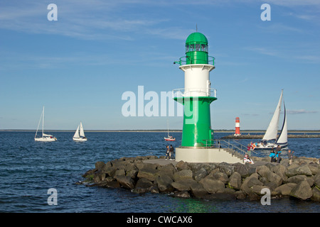 Barche a vela passando i fari alla foce del fiume Warnow, Warnemuende, Meclemburgo-Pomerania Occidentale, Germania Foto Stock