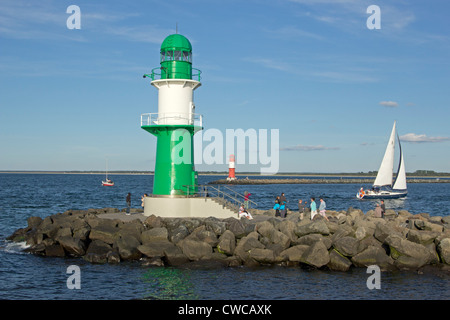 Barca a vela passando i fari alla foce del fiume Warnow, Warnemuende, Meclemburgo-Pomerania Occidentale, Germania Foto Stock