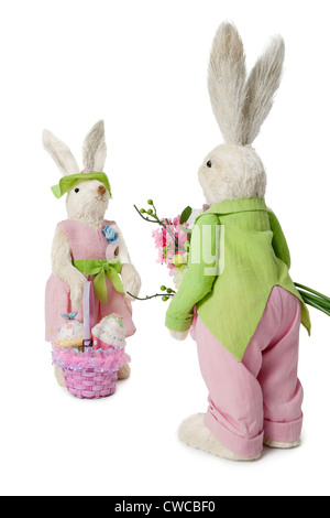 Maschio e femmina di conigli con bouquet di fiori e cesto su sfondo bianco Foto Stock