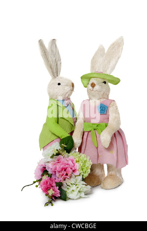 Maschi e femmine di conigli con bouquet di fiori in piedi su sfondo bianco Foto Stock