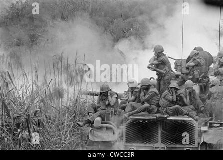 Guerra del Vietnam. Marines equitazione sopra un M-48 il coperchio del serbatoio le loro orecchie come il 90mm pistola spara a sud-ovest di Phu Bai. Il 5 aprile 1968. Foto Stock