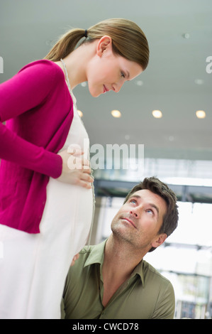 Uomo che guarda una donna in stato di gravidanza Foto Stock