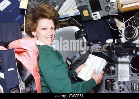 Il comandante Eileen Collins consulta una lista di controllo presso il ponte di volo del Comandante in stazione navetta Columbia. Luglio 24, 1999. Foto Stock