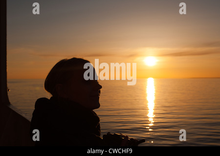 Bellissimo tramonto, donna gode la calma atmosfera del Mar Baltico Foto Stock