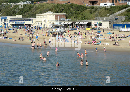 La gente sulla spiaggia e nuoto in mare a Bournemouth Foto Stock