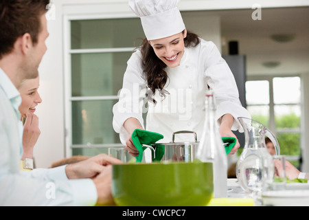 Felice chef femmina che serve cibo Foto Stock