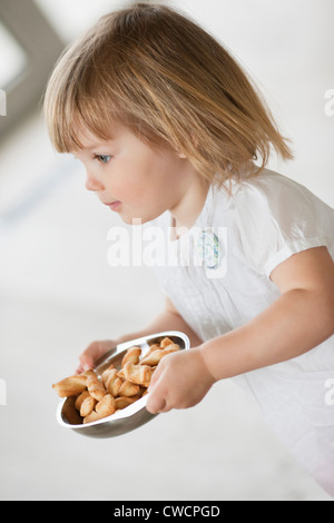 La ragazza che porta una ciotola di cibo Foto Stock