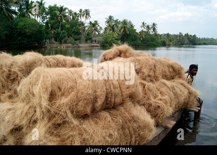 Materie prime di prodotti di cocco trasportati dalla piccola scala industrie di cocco attraverso il Kerala Backwaters da canoe di legno barche Foto Stock