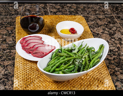 Carni suine fresche, fagioli verdi, immersione e salsa di vino rosso sul bancone di pietra Foto Stock