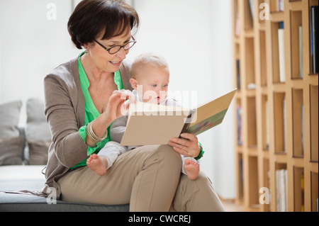 Donna con il suo nipote la lettura di un libro di fotografia Foto Stock