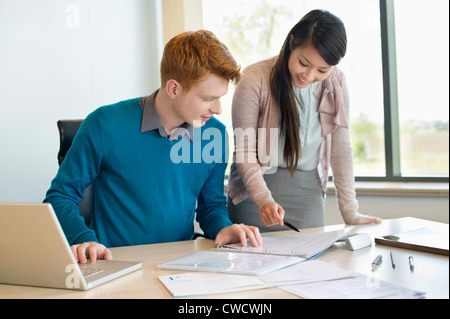 Imprenditore esaminando i documenti con il suo segretario Foto Stock