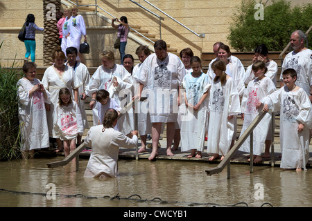 Un sacerdote battezza una famiglia di Betania al fiume Giordano Foto Stock