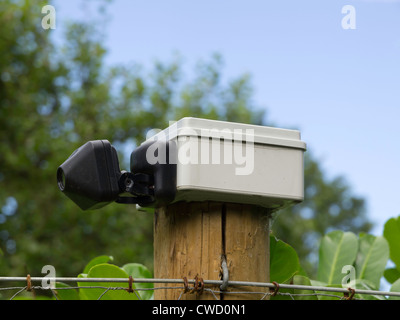 Una piccola protezione CCTV telecamera montata su un palo da recinzione in una zona rurale. Foto Stock