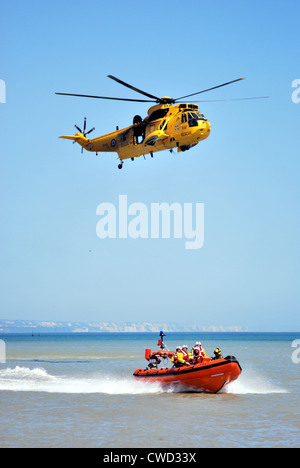 Littlestone RNLI scialuppa di salvataggio in base nel Kent in mare la formazione con un RAF Salvataggio in elicottero in un giorno chiaro. Foto Stock